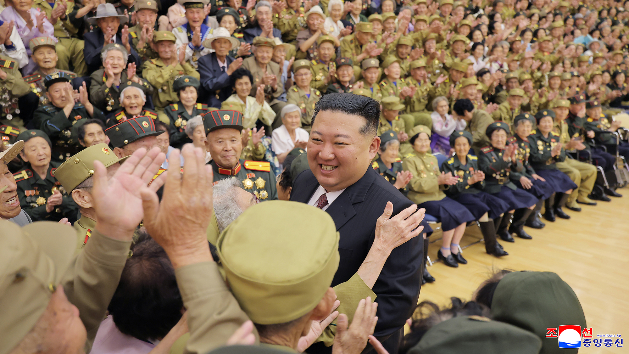 Respected Comrade Kim Jong Un meets and has photo taken with war veterans and persons of wartime merit
