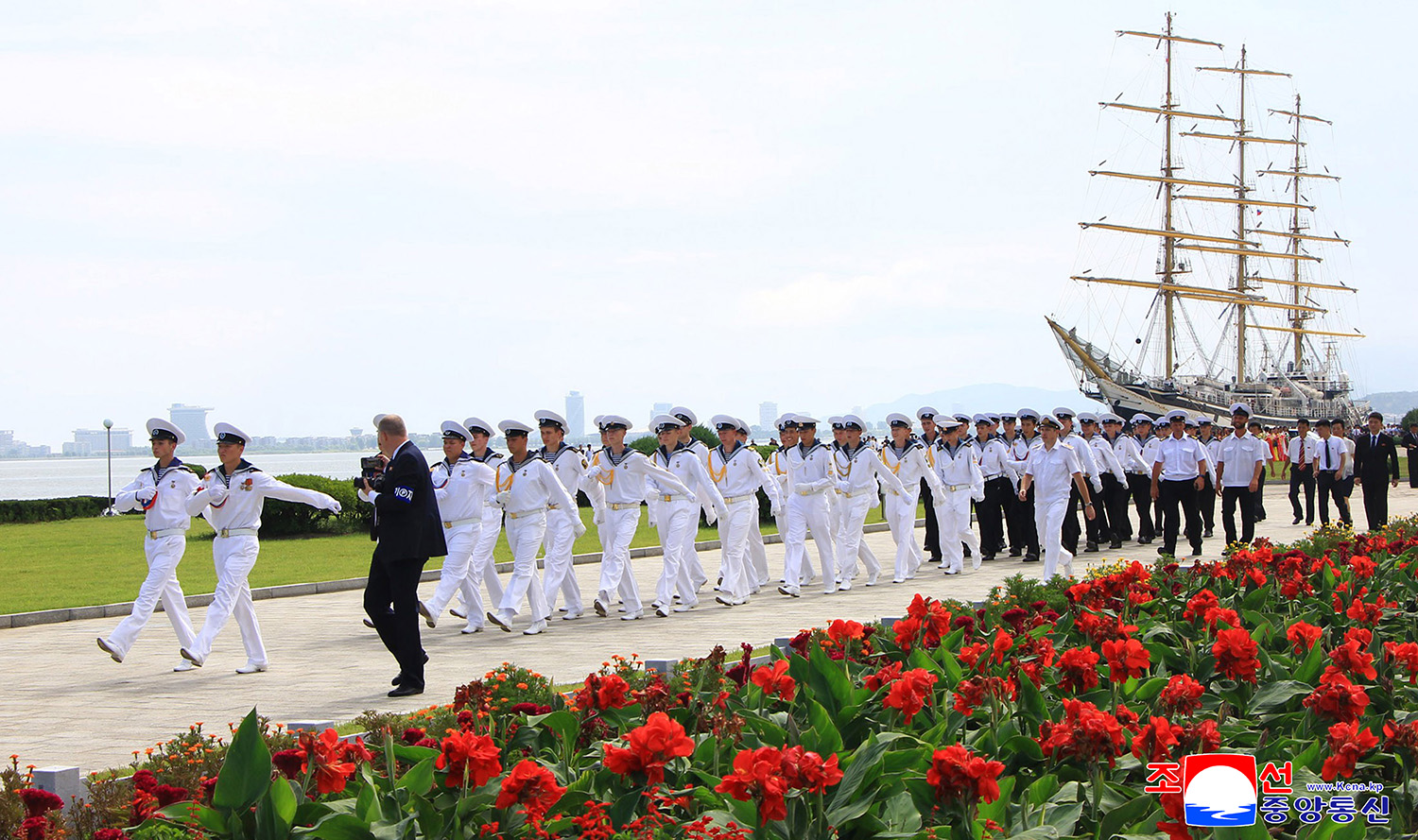 Sailors of Russian sailing ship place flower basket at statues of great leaders